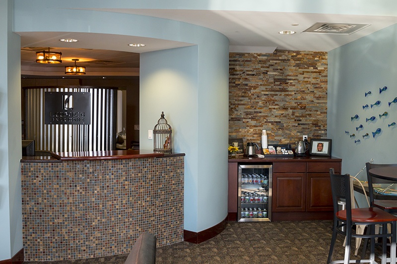 Lakewinds Dental Centre front office area with amenities like coffee, a refrigerator with drinks, and a seating area